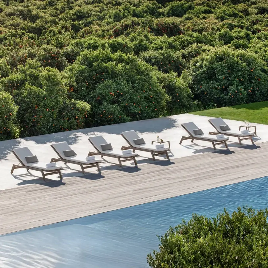 Distinguished Ethimo Costes lounger crafted from FSC-certified teak with light gray textile upholstery and a warm natural finish