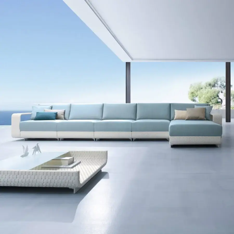 Superior Roberti Rattan Hamptons sectional sofa with aluminum frame and muted blue cushions in textured off-white woven finish