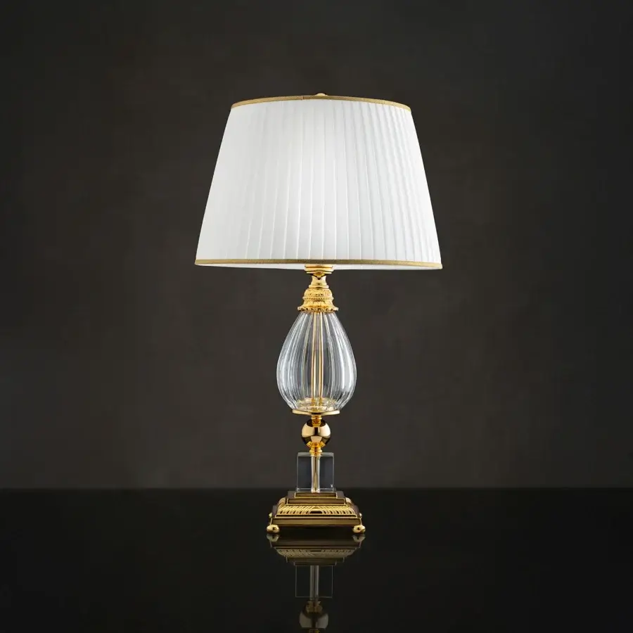 Distinguished Laudarte Cordelia table lamp crafted in Italy with bronze castings, clear crystal and 24K gold plating with an off-white lampshade