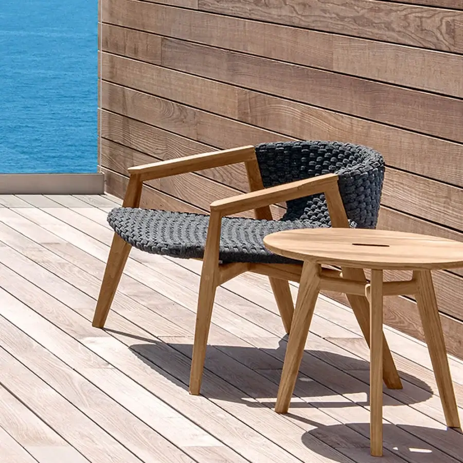 Sophisticated Ethimo Knit lounge chair with a dark gray high-density woven rope seat and FSC-certified teak frame