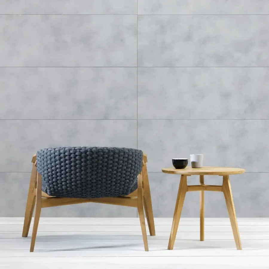 Elegant Ethimo Knit lounge chair with woven deep navy seat and back built with a sinuous FSC-certified teak frame