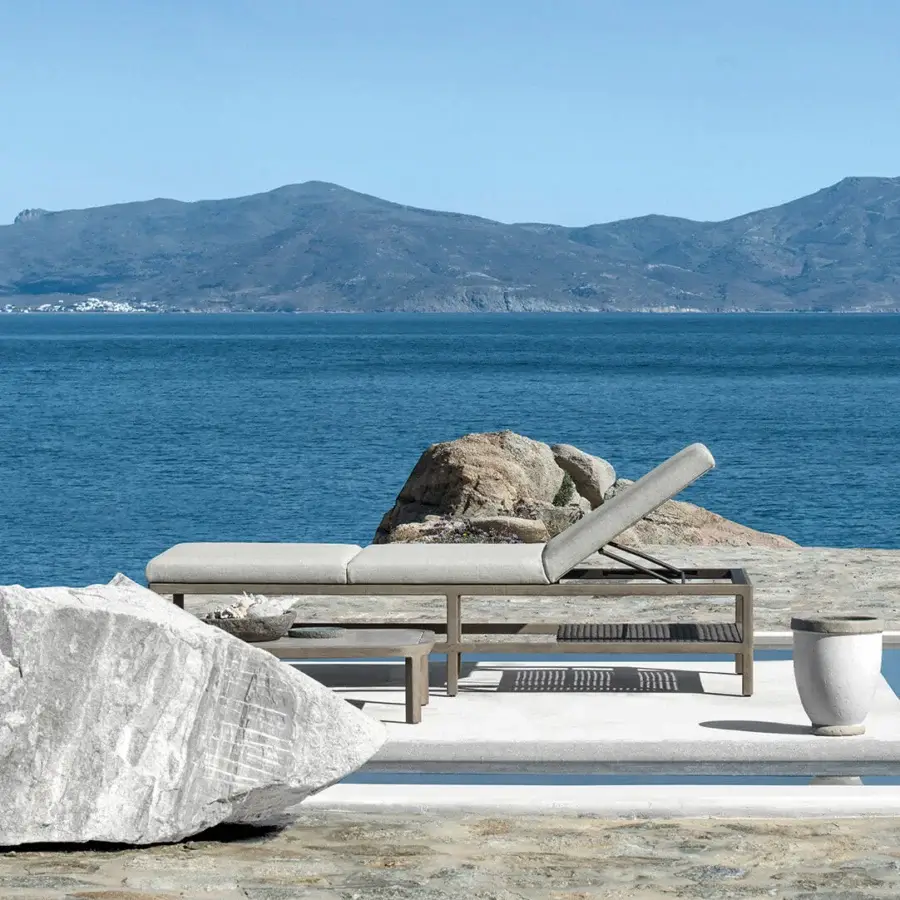Elegant Ethimo Grand Life lounger with neutral gray textile cushion and matte gray metal frame built with a wooden slat base