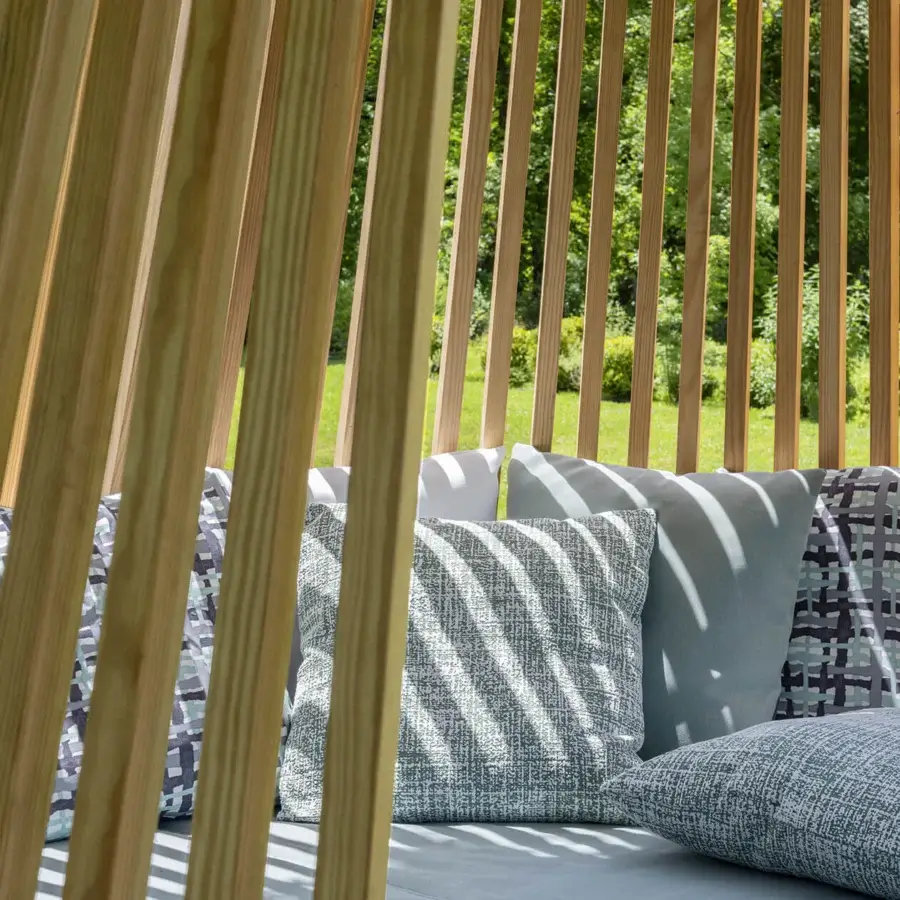 Sophisticated Ethimo Hut daybed crafted in light-toned wood with satin finish and comfortable light blue, gray cushions