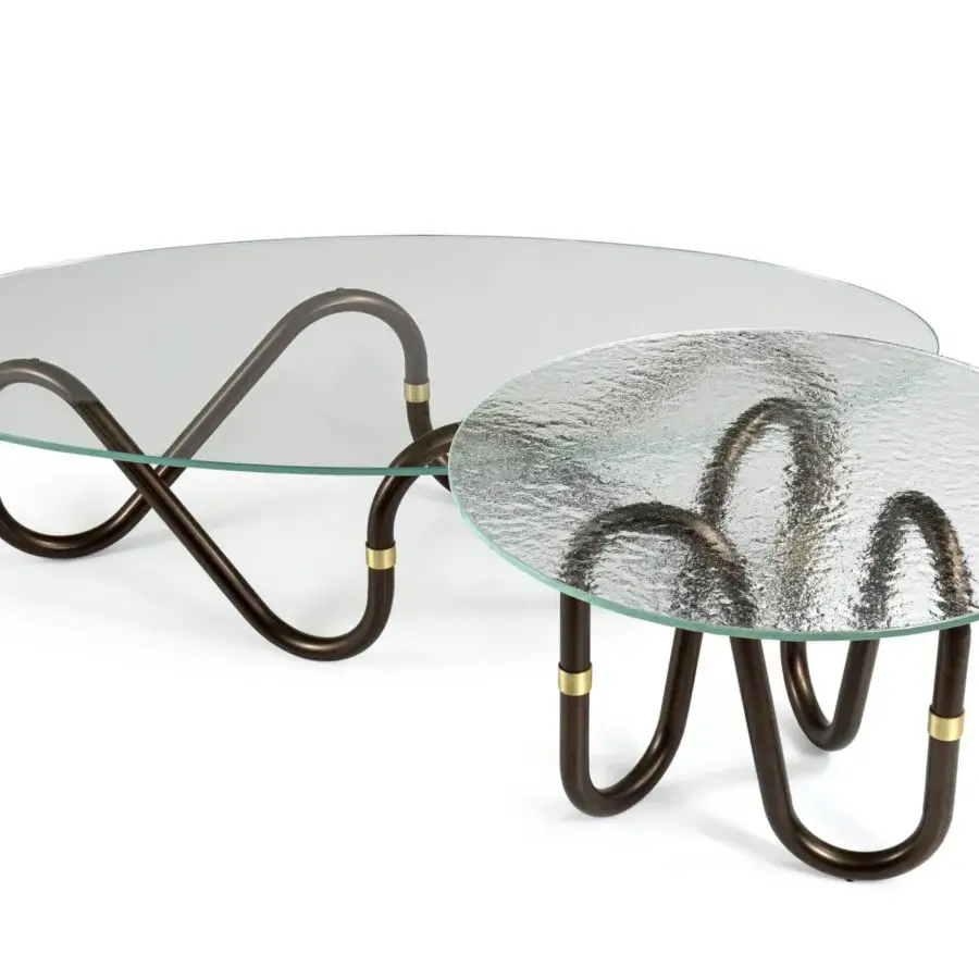 Elegant Borzalino Flow coffee table with clear glass top and continuously curved dark-toned metal base crafted with a brass joint ring