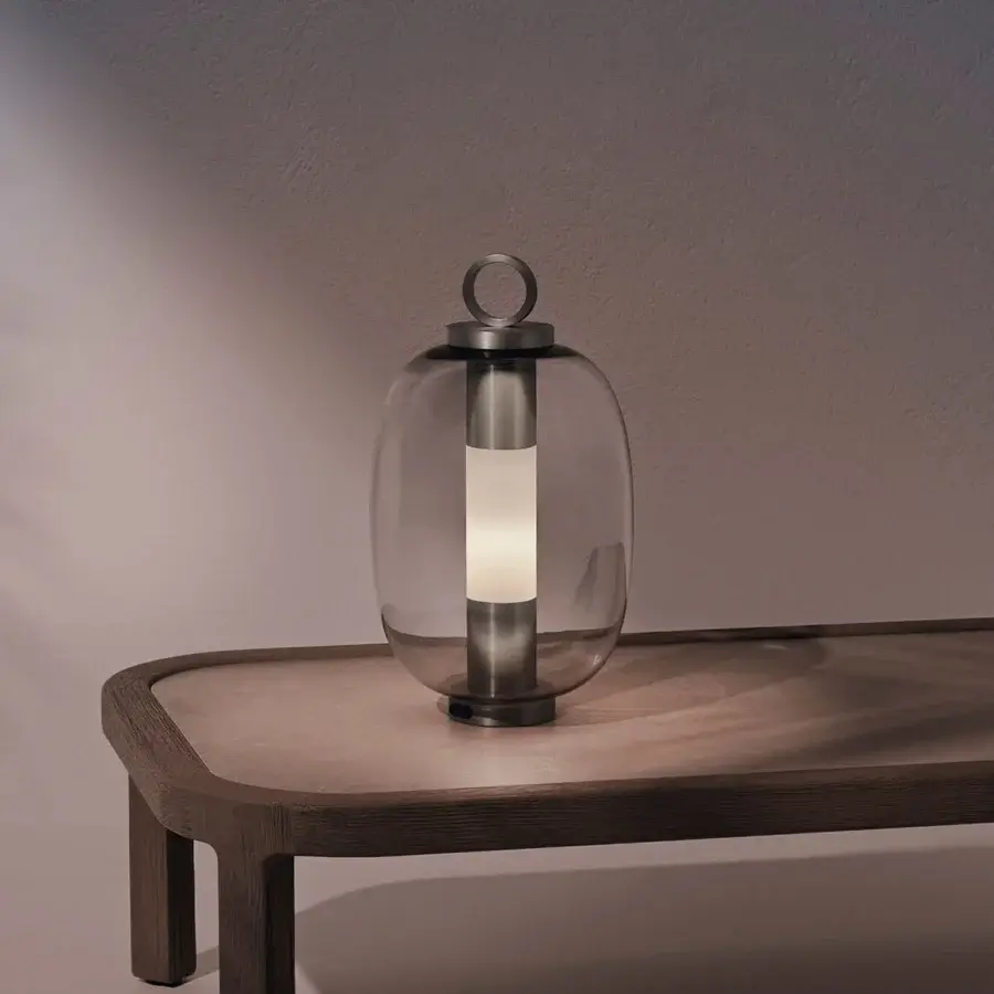 Distinctive Ethimo Lucerna table lamp crafted in Italy with dark-toned metal and satin finish, presenting a translucent shade with warm illumination