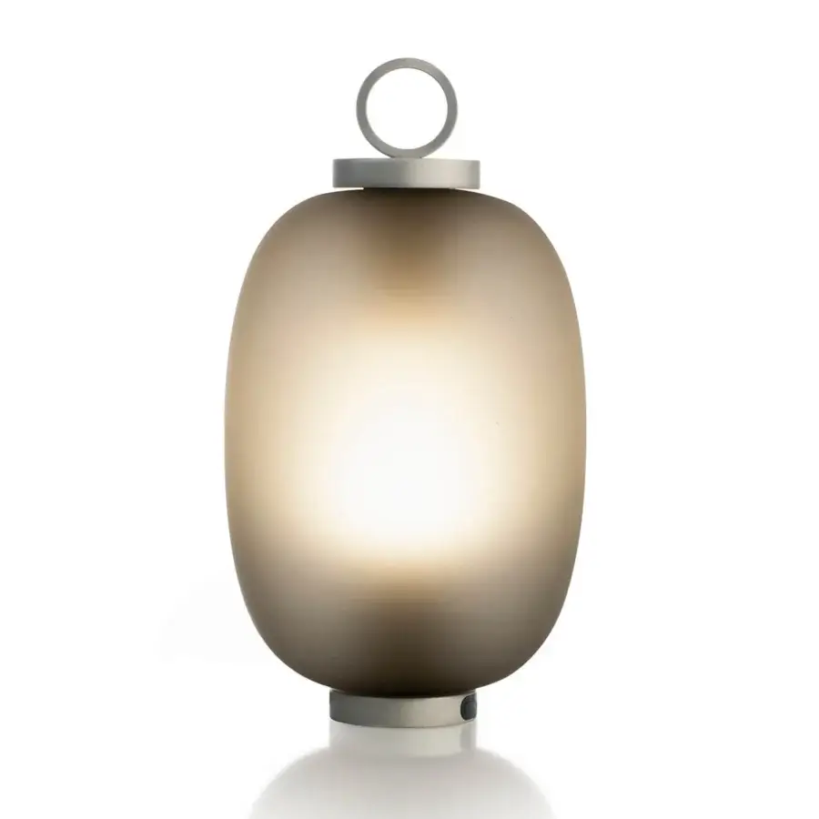 Exceptional Ethimo Lucerna table lamp crafted in Italy with translucent glass and satin-finish metal, emitting a warm amber glow