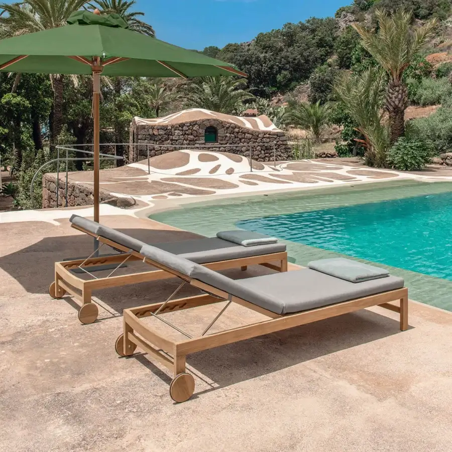 Sophisticated Ethimo Sand lounger with a satin-finish brown wood frame and comfortable gray textile cushion for relaxing moments