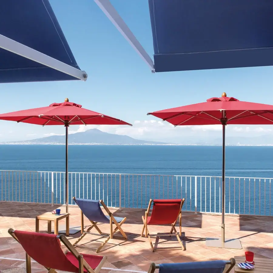 Sophisticated Ethimo Free Umbrella parasol in red textile with a smooth metal pole crafted in Italy
