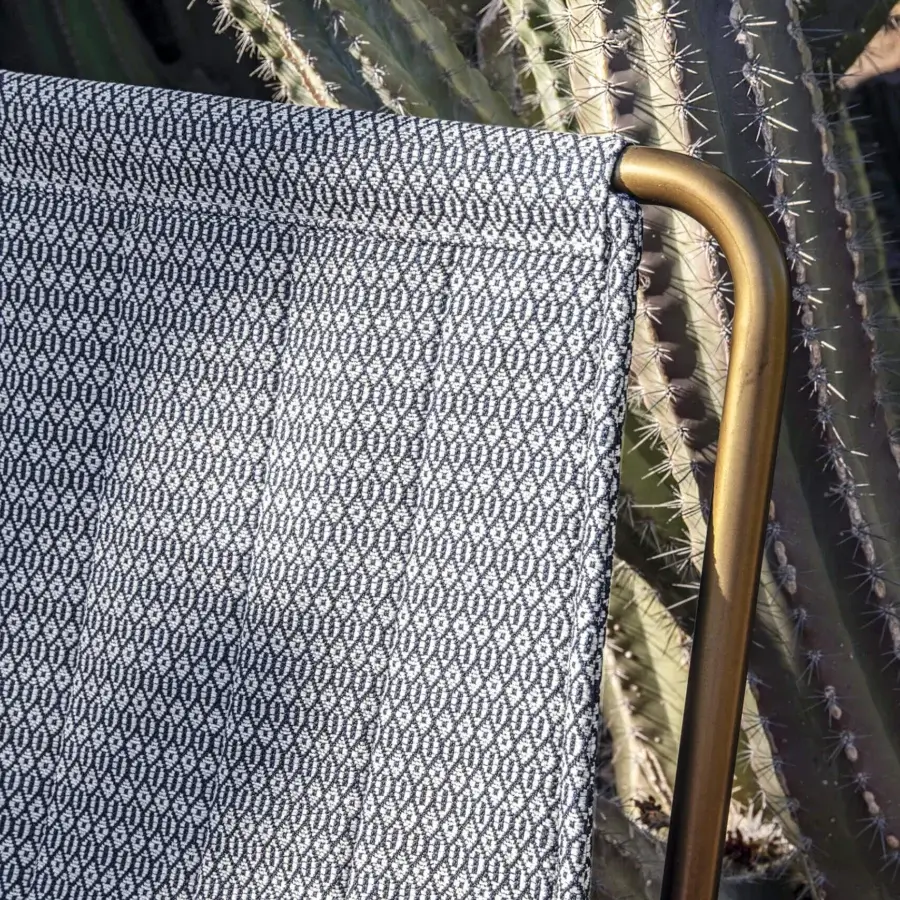 Distinguished Ethimo Sling lounge chair with dark blue and white geometric patterned sling and brass-finished metal frame