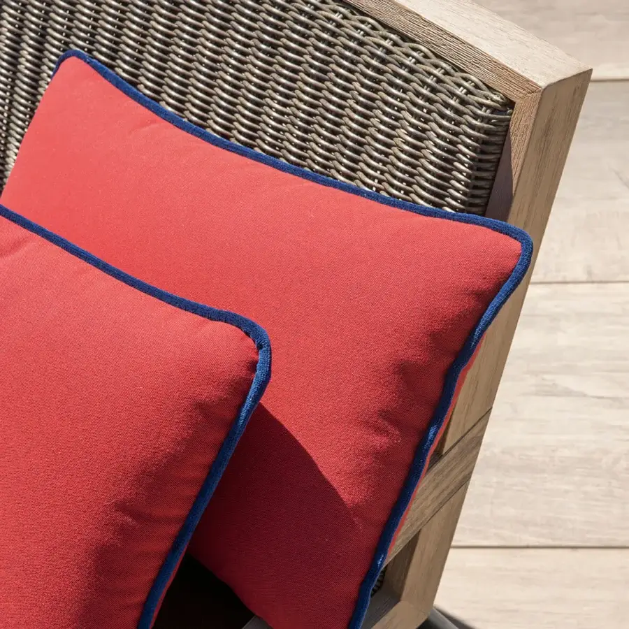 Sophisticated Ethimo Allaperto lounge chair with light-toned wood frame and matte red textile cushions featuring blue trim