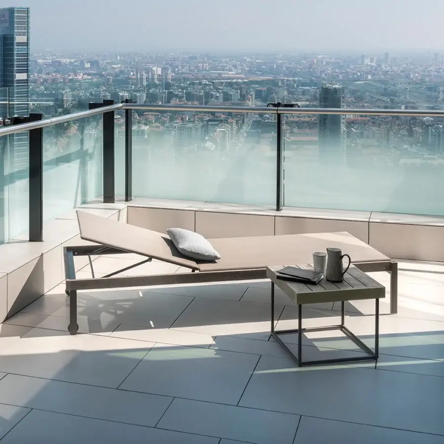 Elegant Ethimo Allaperto lounger with a beige wood-like composite frame and light gray cushion in matte finish