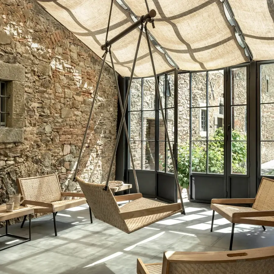 Distinguished Ethimo Allaperto Swing lounge crafted in light to medium brown wood with woven textile and matte dark metal frame