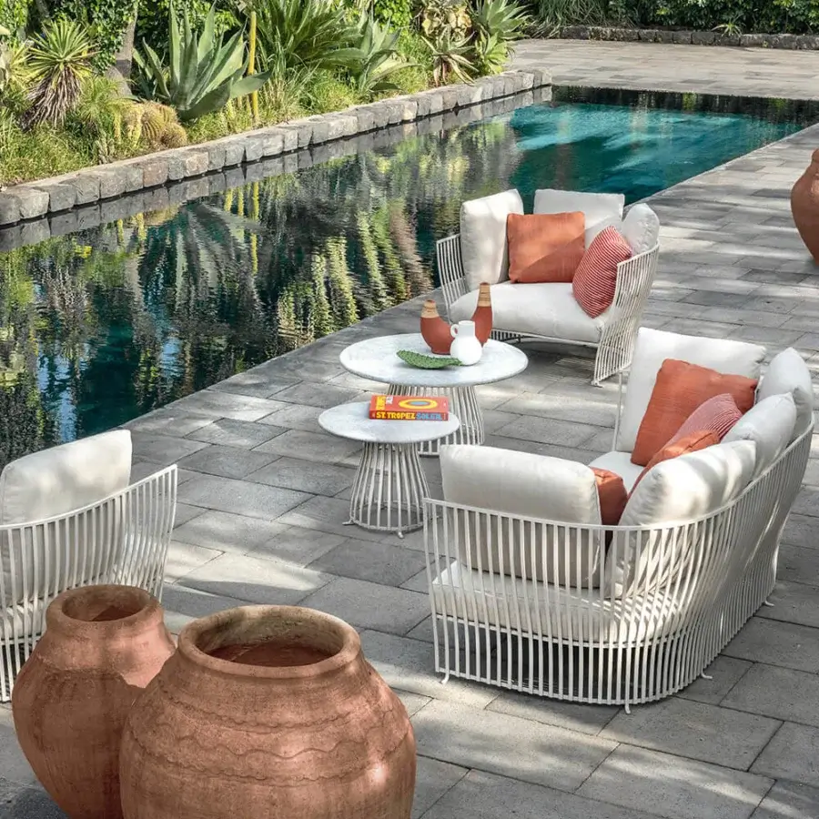Architectural Ethimo Venexia coffee table with a circular light-colored stone top and visually light aluminum slat base crafted in Italy