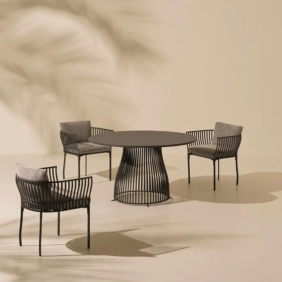Elegant Ethimo Venexia table with woven aluminum cage base and smooth enamelled lava stone top in dark gray finish