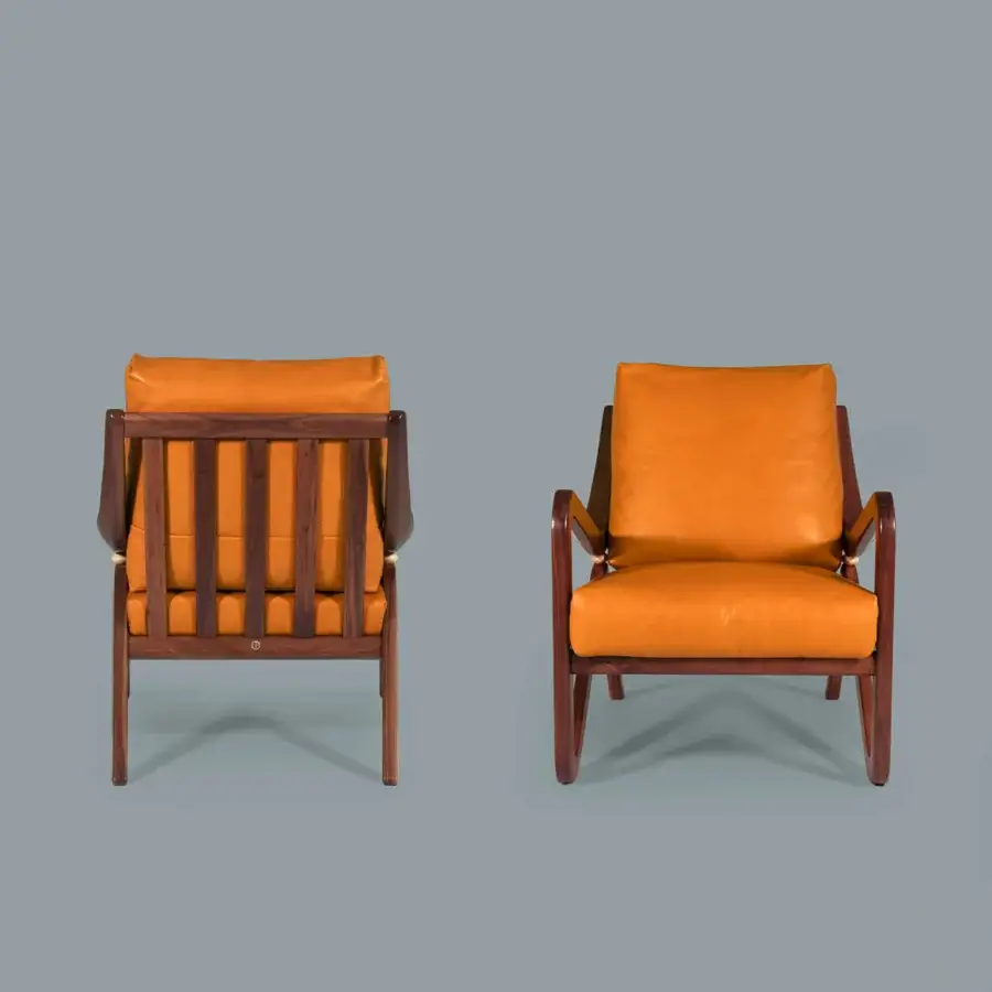 Superior Borzalino Taylor armchair with smooth orange-brown leather upholstery and hand-carved lacquered wood frame