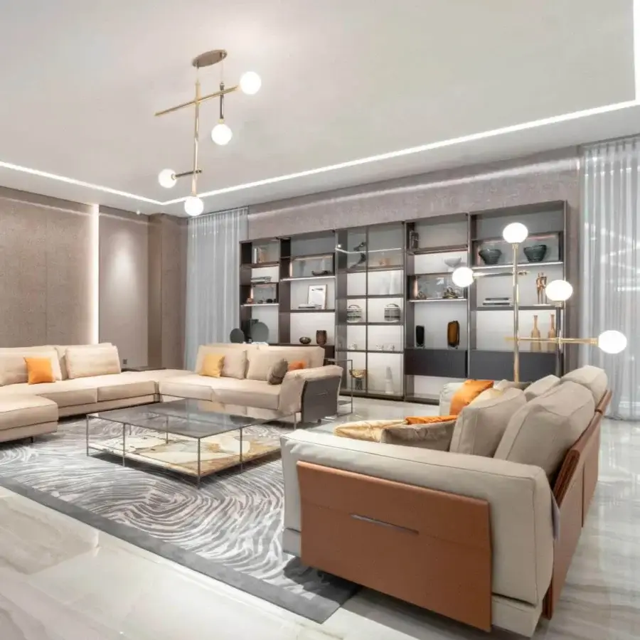 Superior Visionnaire Anthem sofa built with laminate and MDF, upholstered in smooth matte beige textile with reddish-brown satin accents and orange cushions