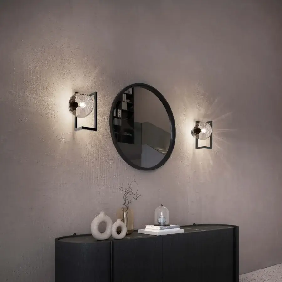 Distinguished Vistosi Globose wall lamp crafted in matte black metal with a hand-blown clear glass sphere and textured interior