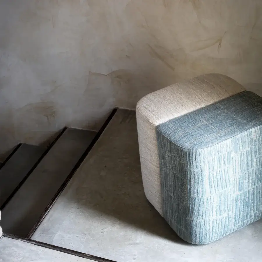 Lavish Carpanese Home Rocha ottoman built with light blue-grey striated textile and a neutral beige top