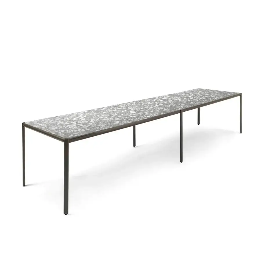 Elegant Giorgetti Aldìa table built with dark matte metal legs and a speckled gray terrazzo-like composite surface