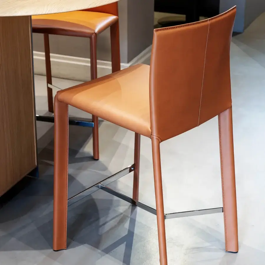 Distinguished Frag Blyn bar stool crafted with full saddle leather upholstery and a sleek chrome X-shaped base