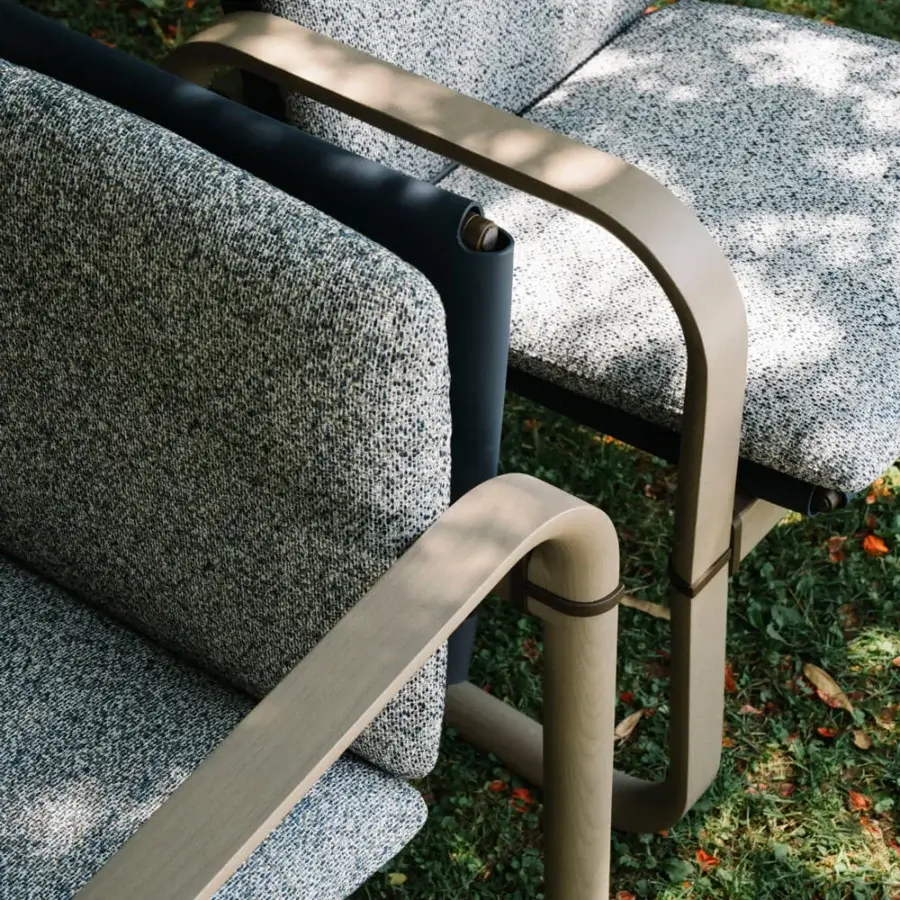 Elegant Giorgetti Loop armchair with grey water-polished ash wood and carob-toned aluminum details, upholstered in muted gray textile cushions