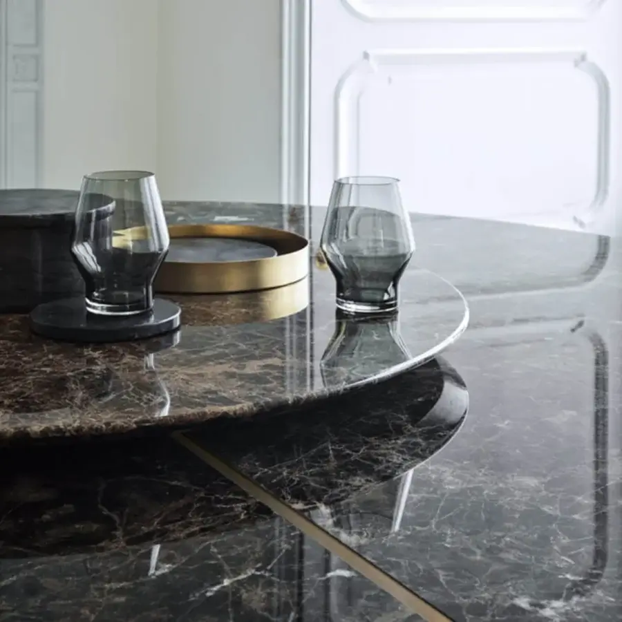 Exceptional Frag Artù dining table crafted in Italy with polished marble exhibiting dark grey and brown veining plus a sleek metallic edge and leather base