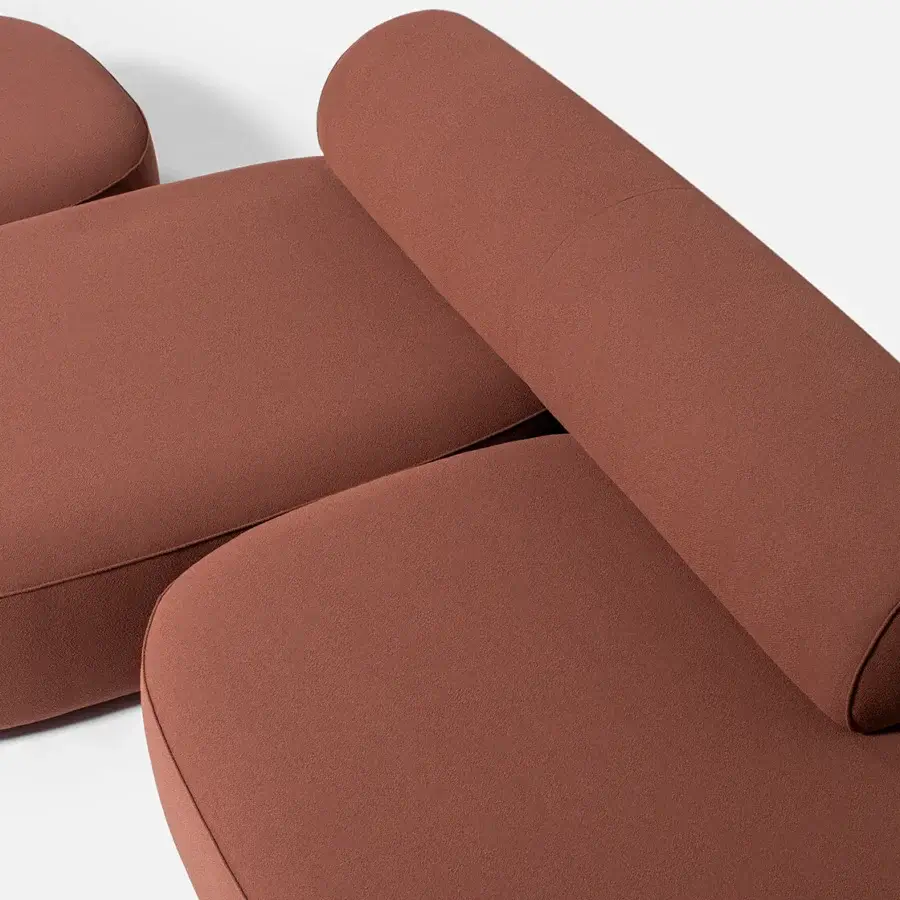 Lavish Carpanese Home Slow sectional with reddish-brown textile upholstery, exposed ash wood supports and a soft matte finish