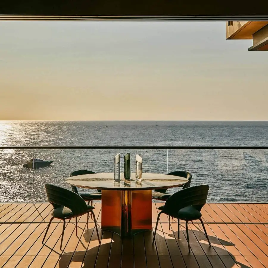 Exceptional Visionnaire Kerwan Outdoor table crafted in Italy with hand-polished amber stainless steel and transparent glass tabletop