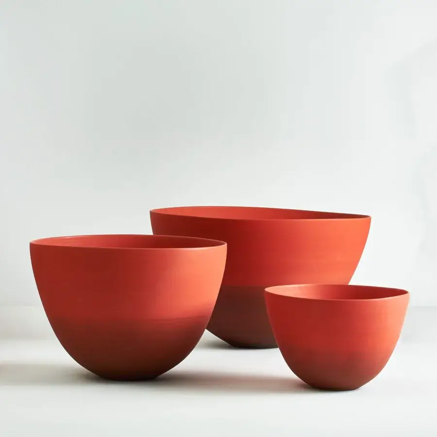 Exquisite Rina Menardi Ciotole bowls crafted from baked clay with warm reddish-orange tonal variations and gently curved forms