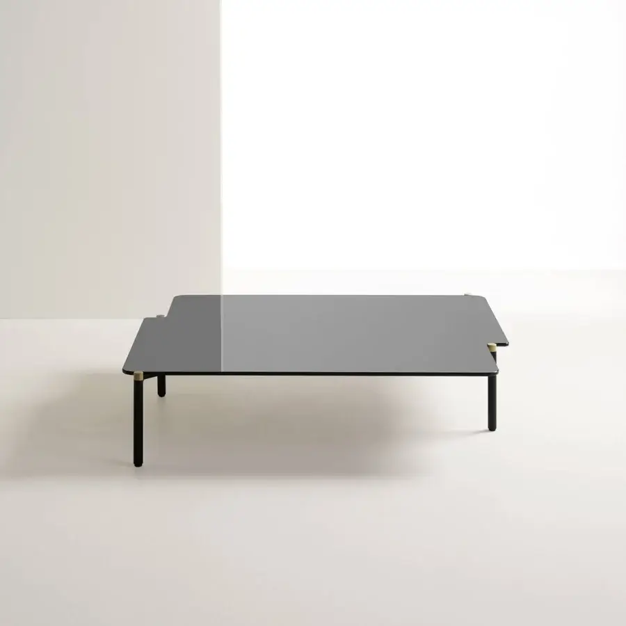 Distinctive Frag Arita coffee table with a subtly asymmetrical dark gray tabletop and burnished brass caps in painted steel