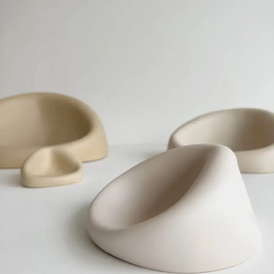 Elegant Rina Menardi Clio centerpiece crafted from baked clay with an organic asymmetrical form and pale creamy beige hue