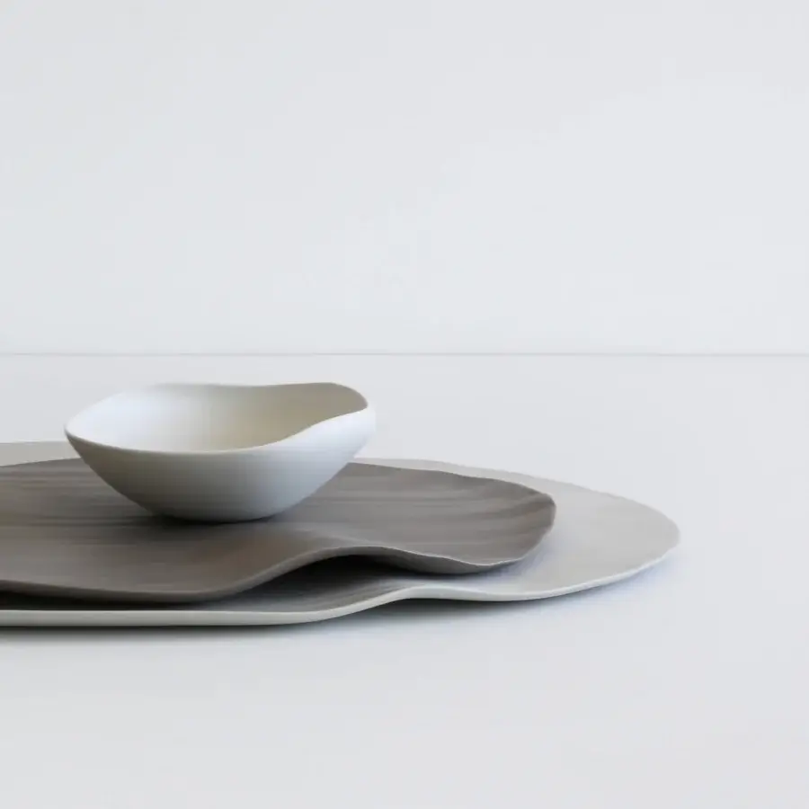 Exclusive Rina Menardi Conchiglie centerpiece crafted from baked clay with bright white and gray organically shaped plates and a matte finish