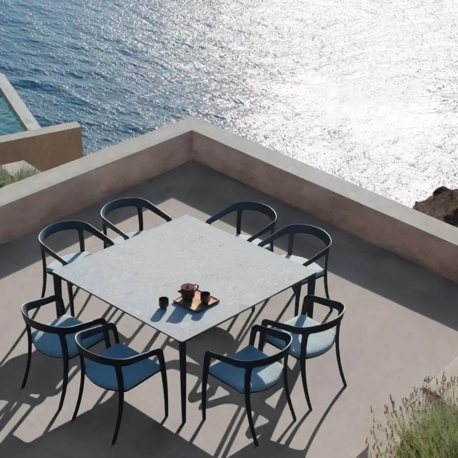Distinguished Royal Botania Jive armchair with tapered black aluminum structure and woven blue olefin seat crafted with teak backrests