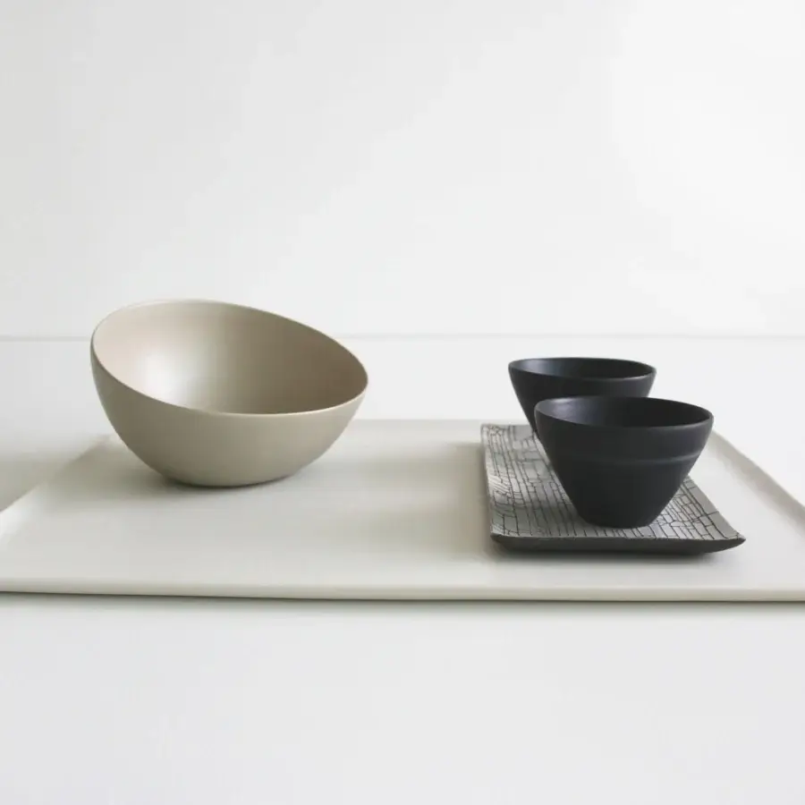 Exclusive Rina Menardi Nidi vase crafted in Italy with a gently curved asymmetrical bowl and smooth matte beige ceramic