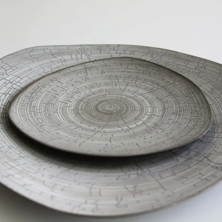 Exceptional Rina Menardi Triangolo centerpiece, a handcrafted ceramic dish with linear patterns and muted gray matte finish