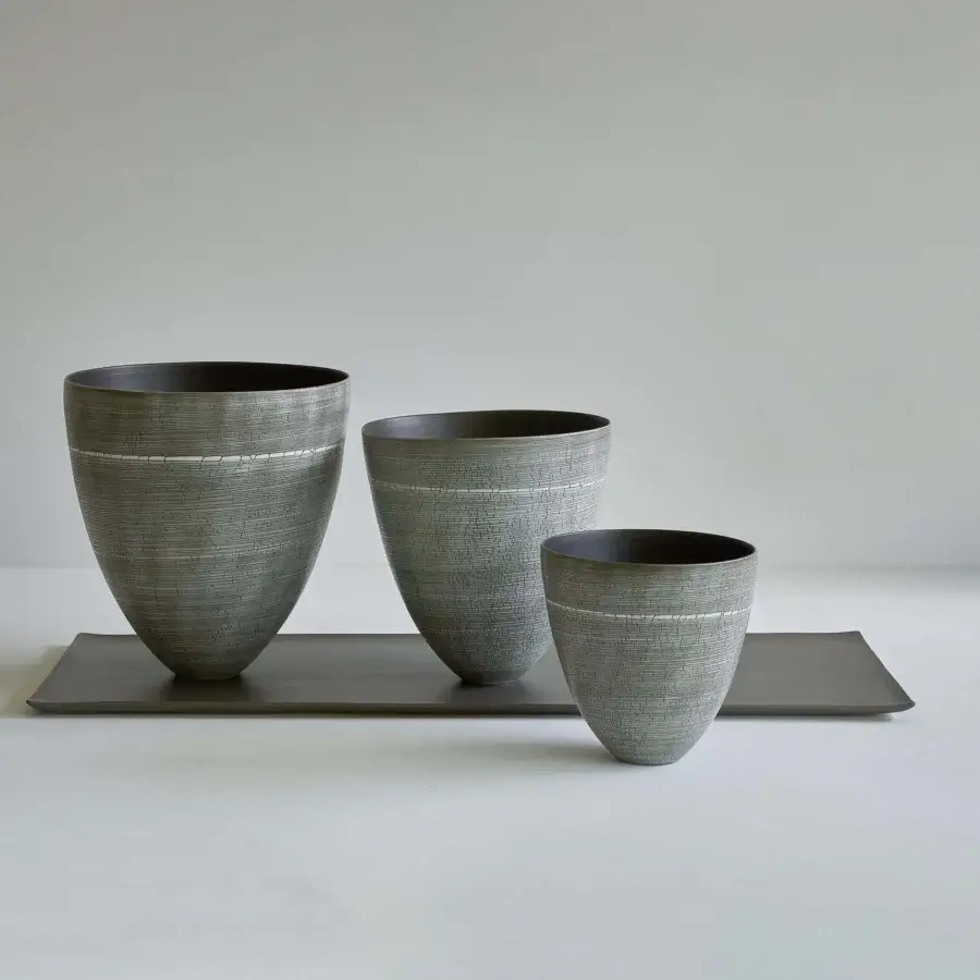 Distinguished Rina Menardi Vassoi Rettangolari centerpiece tray crafted with graduated conical vases in grayish-green textured metal and charcoal interiors