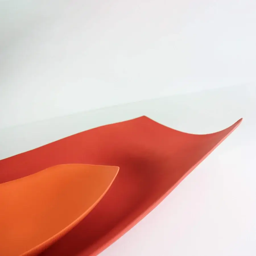 Distinguished Rina Menardi Vassoi Rettangolari Onde trays in vibrant orange-red with an organic undulating form and smooth matte finish