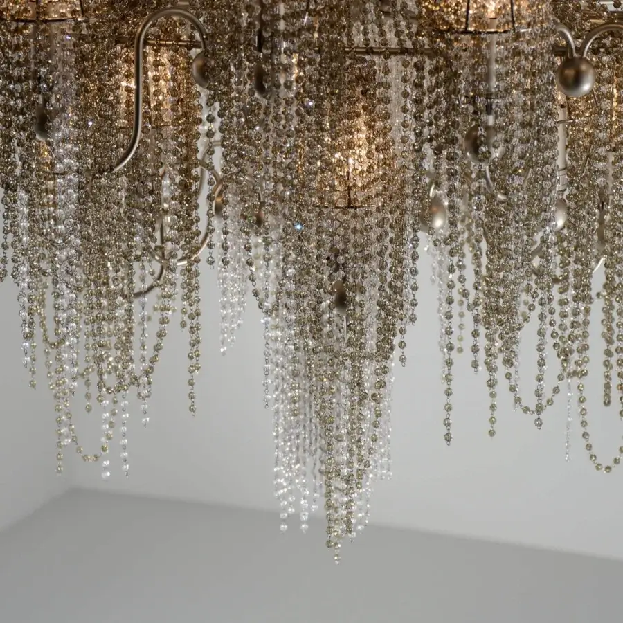 Distinguished Patrizia Garganti Burlesque chandelier with cascading clear and golden beads draped over a textured brass-toned metal frame