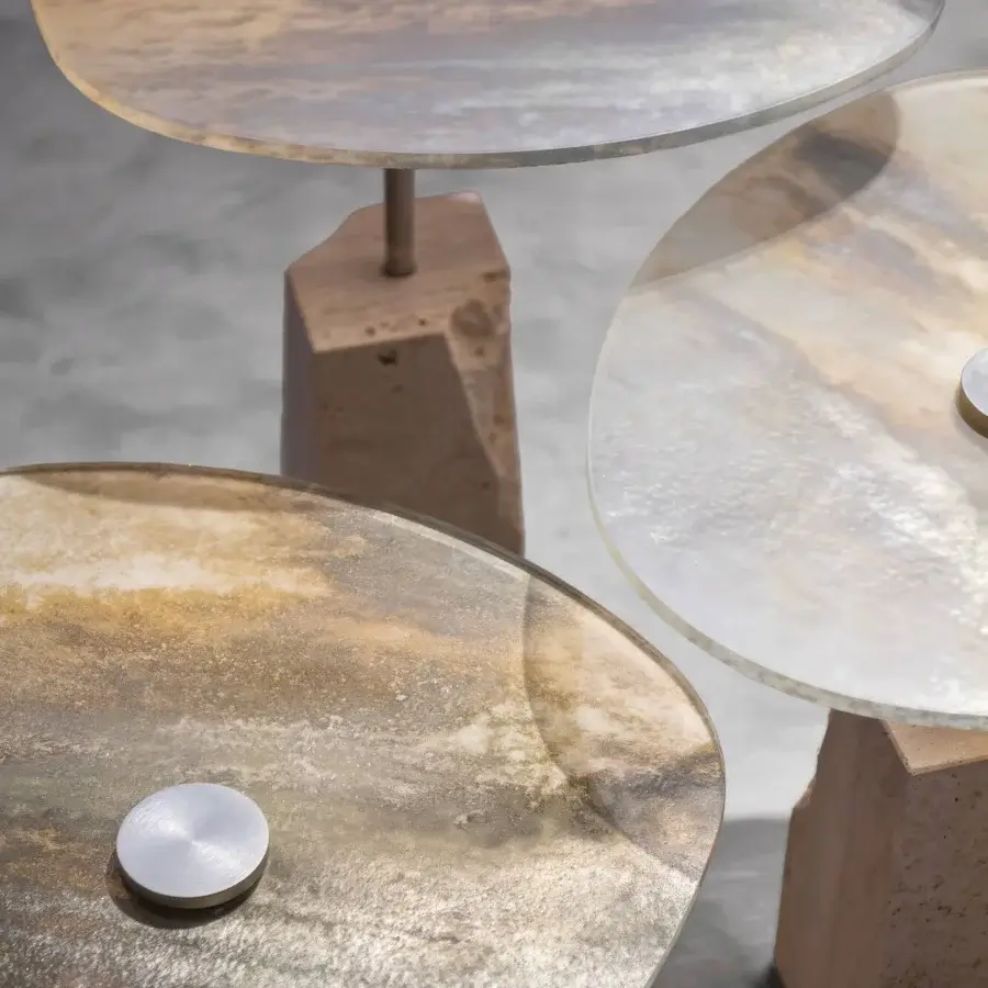 Superior Arte Veneziana Rascino side table with extra-clear baked glass displaying swirling amber, gold, and beige tones, built with a textured travertine base and satin steel