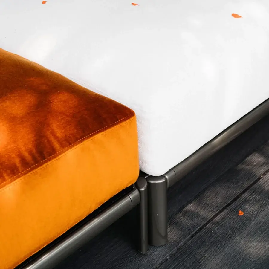 Lavish Giorgetti Aldìa ottoman with sleek painted metal frame and plush waterproof orange-brown fabric upholstery