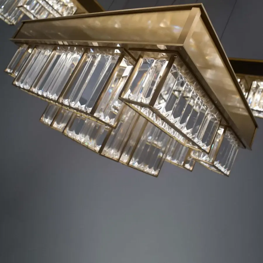 Elegant Patrizia Garganti Gisele chandelier crafted in warm gold tone steel with clear glass prisms and dimmable LED lighting