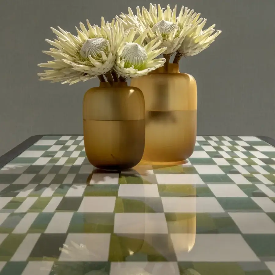Exceptional Black Tie Caius table with checkered green and white glass tabletop and warm golden-brown legs exhibiting a glossy finish