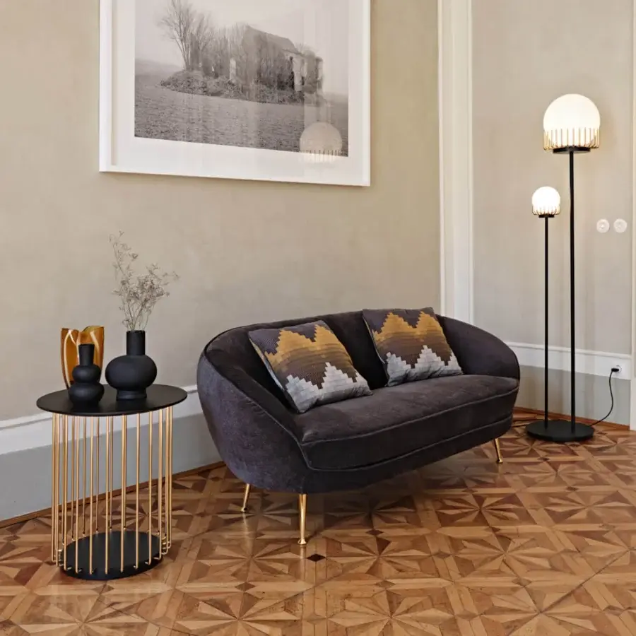 Distinguished Black Tie Etan side table with round top and slender gold-toned metal rod structure in lacquered MDF