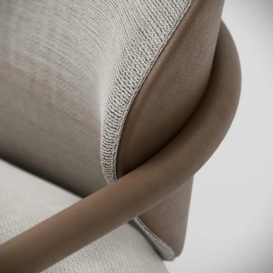 Distinctive Capital Flora armchair with enveloping curves upholstered in neutral beige textile with light brown tubular leather armrests and galvanic aluminum structure