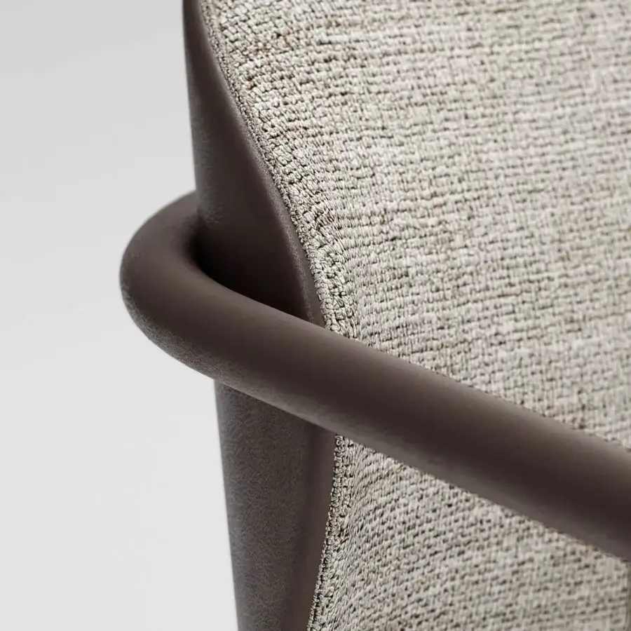 Elegant Capital Flora armchair with soft sinuous curves and light beige textured textile upholstery with a galvanic finish aluminum frame