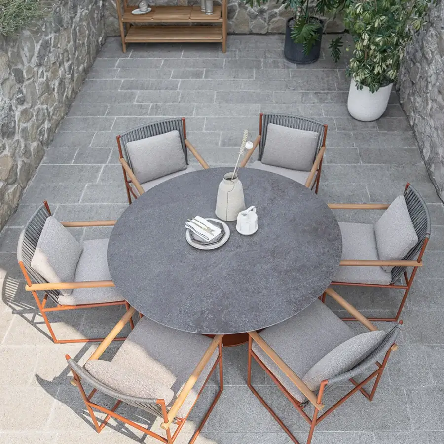 Exceptional Atmosphera Pipe armchair with warm terracotta epoxy-coated steel, light gray hand-woven acrylic cord, and rounded teak armrests