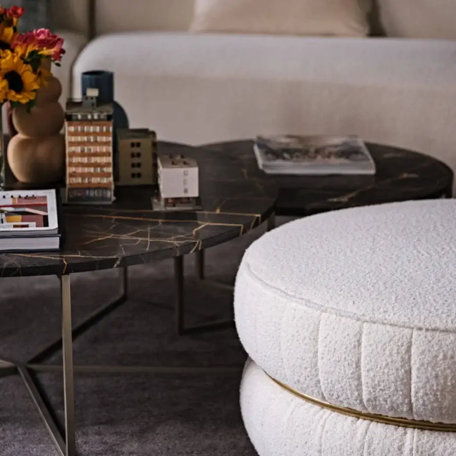 Elegant Black Tie Lillo ottoman with textured off-white bouclé textile upholstery and gilded metal accent