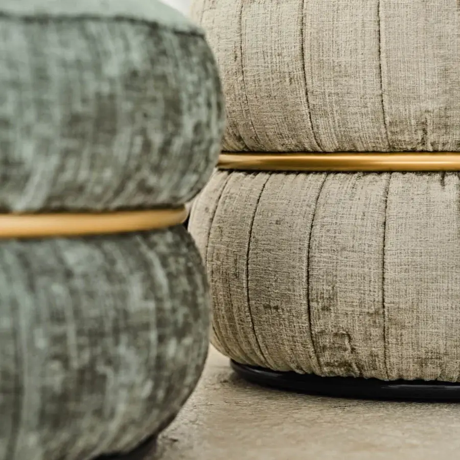 Distinguished Black Tie Lillo ottoman with muted grey-beige textile upholstery, ribbed stitching and a black metal base with golden accents