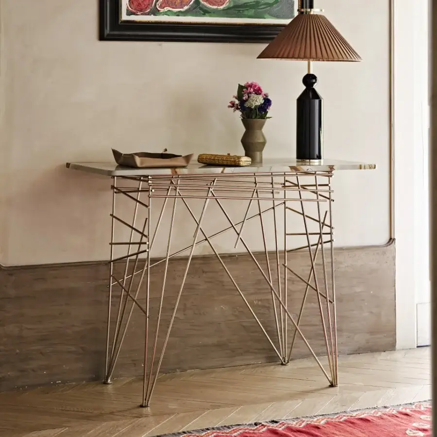 Elegant Black Tie Lin console with clear glass top and coppery-gold toned steel base exhibiting a satin finish