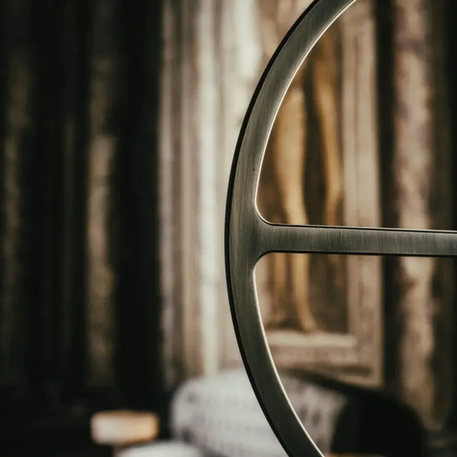Exceptional Black Tie Mou mirror crafted in Italy with a matte gunmetal-grey metal frame and wheel-like composition